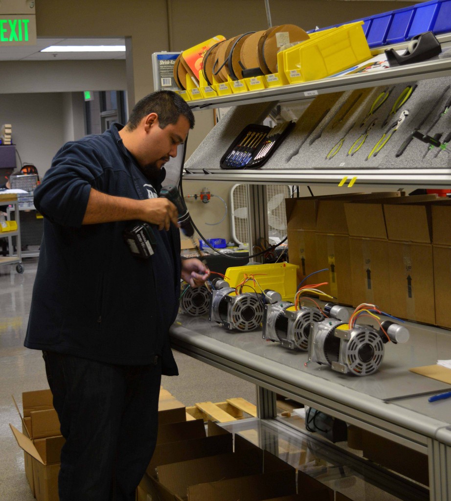 Production worker stands focused at ergonomic work station
